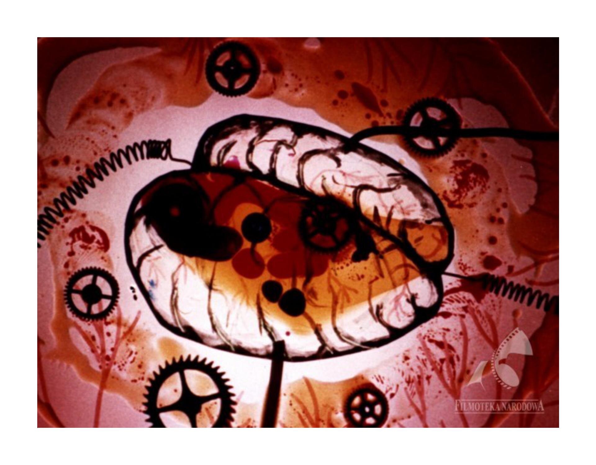 Kadr z filmu „Jak działa Jamniczek”. Jest abstrakcyjna ilustracja w kolorach od bladoróżowego, poprzez pomarańczowy do ciemnoczerwonego. Kontury, linie i elementy takie jak sprężyny, tryby są w kolorze czarnym. 