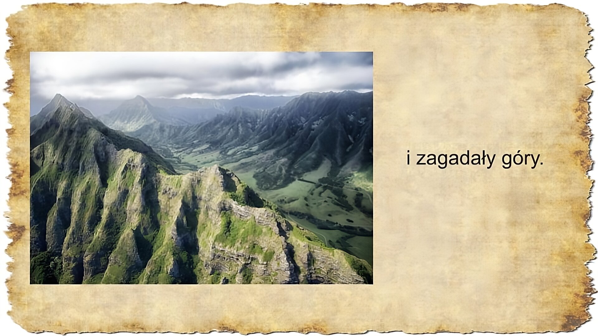 Po prawej stronie slajdu zamieszczony jest tekst: i zagadały góry. Po lewej stronie slajdu umieszczona jest kolorowa fotografia przedstawiająca górski krajobraz. Na pierwszym planie widoczne są kamienne szczyty gór porośnięte trawą. Na drugim planie znajduje się dolina rozpościerająca się między górskimi pasmami.