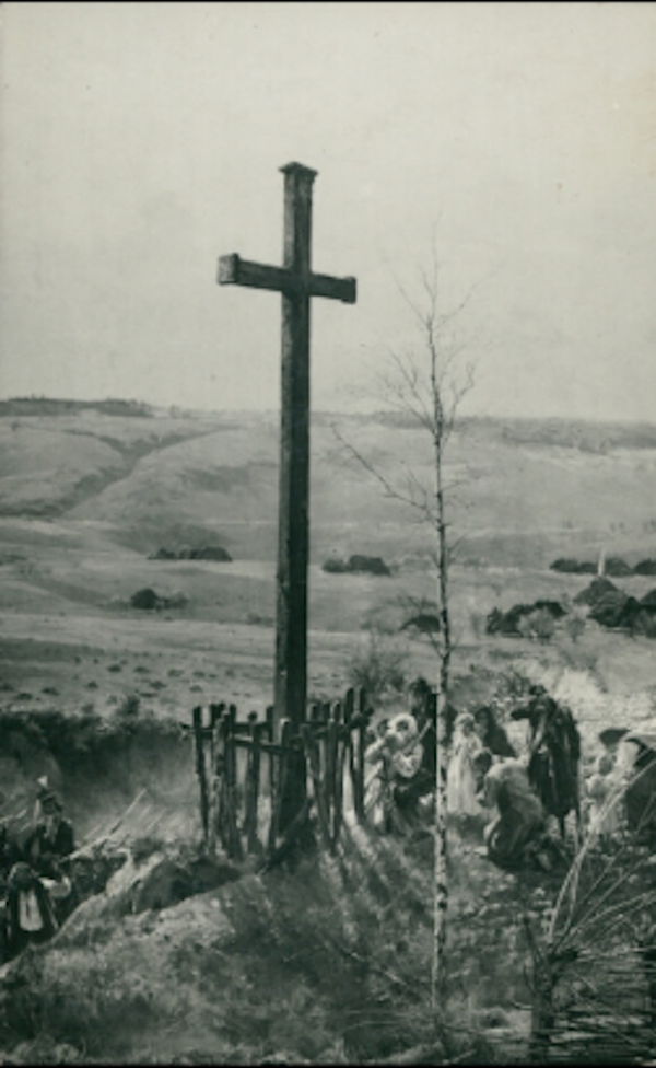 Ilustracja przedstawia panoramę. Na pierwszym planie krzyż otoczony niskim płotkiem. Przy nim klęczący ludzie. Dolina rozciąga się po horyzont. 