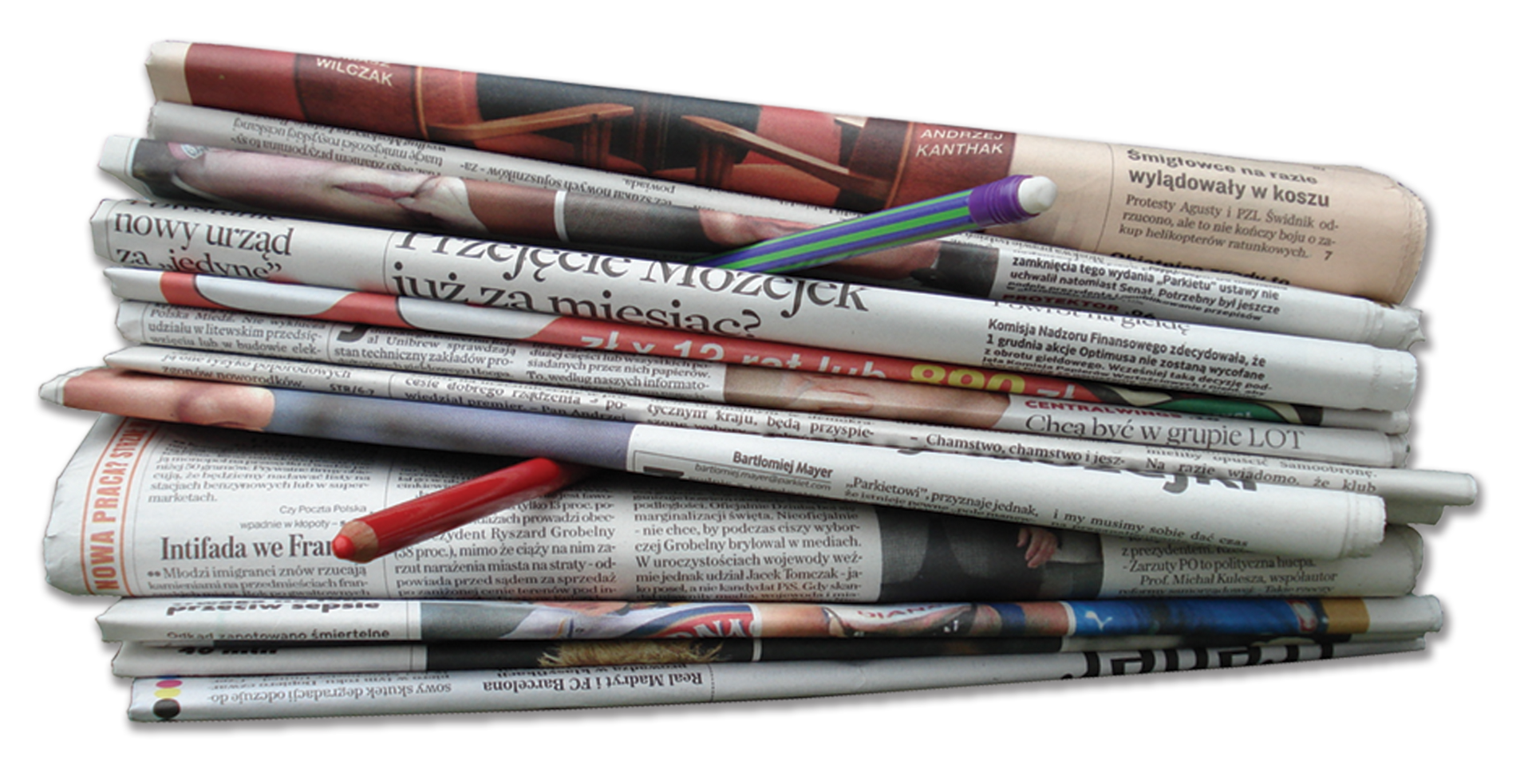 Zdjęcie przedstawia stos ułożonych jedna na drugiej gazet. W jednej trzeciej wysokości stosu z gazet wystaje czerwona kredka. Z kolei w dwóch trzecich wysokości ze stosu wystaje ołówek z gumką.
