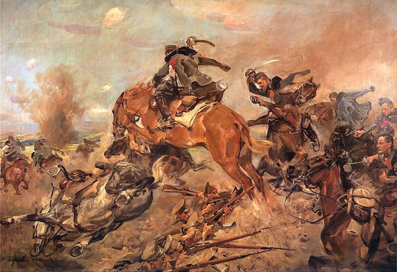 Zdjęcie przedstawia Szarża pod Rokitną. Wojskowi konno ekspresyjnie machają szablami. Bliżej ziemii, w okopach mundurowi z karabinami. Pokonują najeżdżającego przeciwnika. 