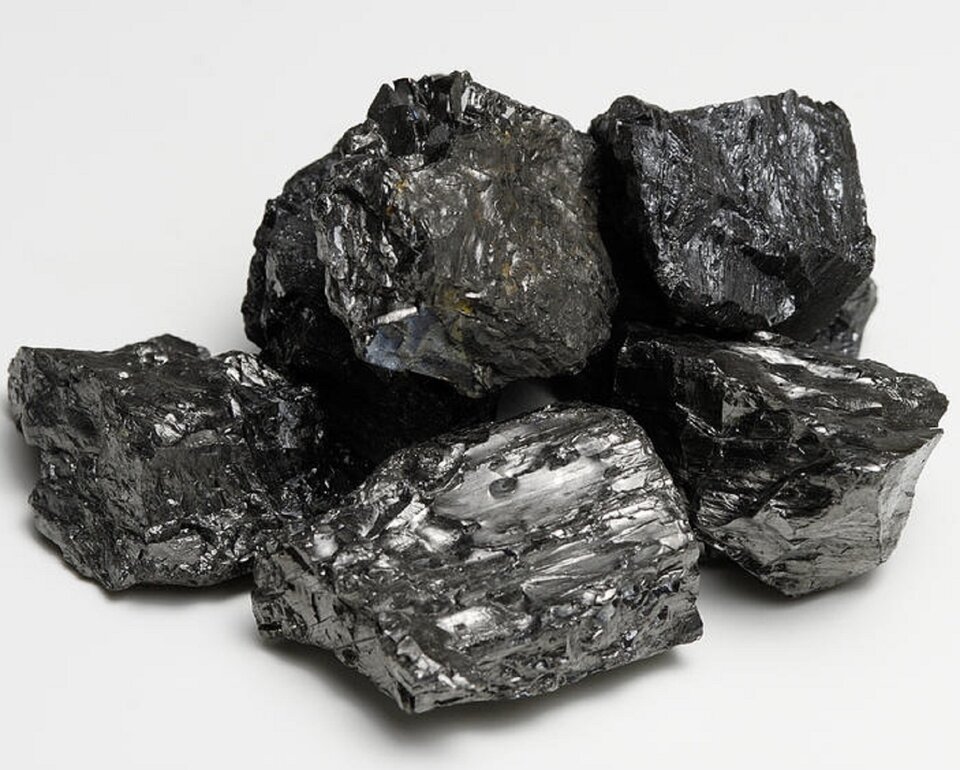 Grafika przedstawia pięć czarnych brył antracytu o nieregularnej, lekko połyskującej na kolor srebrny strukturze.