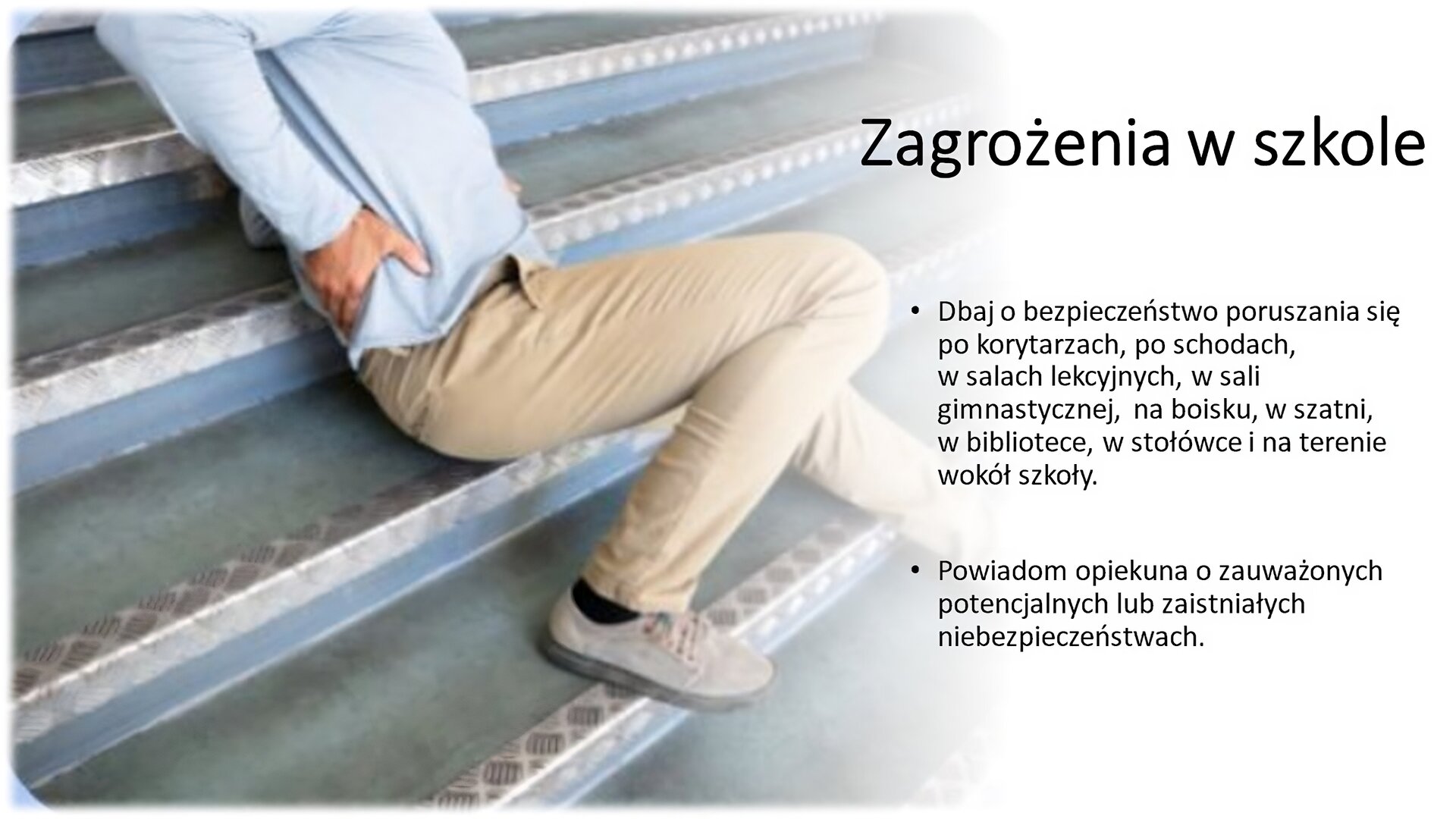 Slajd przedzielony na dwie części. Z lewej strony zdjęcie mężczyzny w kremowych spodniach i błękitnej koszuli. Siedzi na schodach i trzyma prawą rękę na swoich plecach. Z prawej strony tekst: „Zagrożenia w szkole. Dbaj o bezpieczeństwo poruszania się po korytarzach, po schodach, w salach lekcyjnych, w sali gimnastycznej, na boisku, w szatni, w bibliotece, w stołówce i na terenie wokół szkoły. Powiadom opiekuna o zauważonych potencjalnych lub zaistniałych niebezpieczeństwach”.