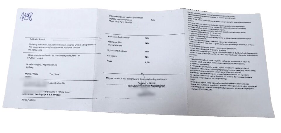Zdjęcie przedstawia ubezpieczenie OC pojazdu. Jest to mały, prostokątny kawałek papieru, na którym są następujące informacje: firma ubezpieczeniowa, zakres ubezpieczenia, marka samochodu, numer rejestracyjny samochodu, dane ubezpieczającego, dane ubezpieczyciela, czy zawarte są inne ubezpieczenia, pieczątka agenta ubezpieczającego.