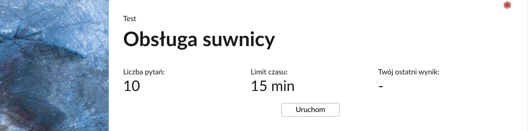 Grafika przedstawia przykładowy wygląd panelu testu. Na środku znajduje się napis "Obsługa suwnicy". Na planszy znajdują się również informacje o liczbie pytań, czasie, w którym należy rozwiązać test, oraz o ostatnim uzyskanym wyniku. Poniżej widać przycisk "Uruchom".