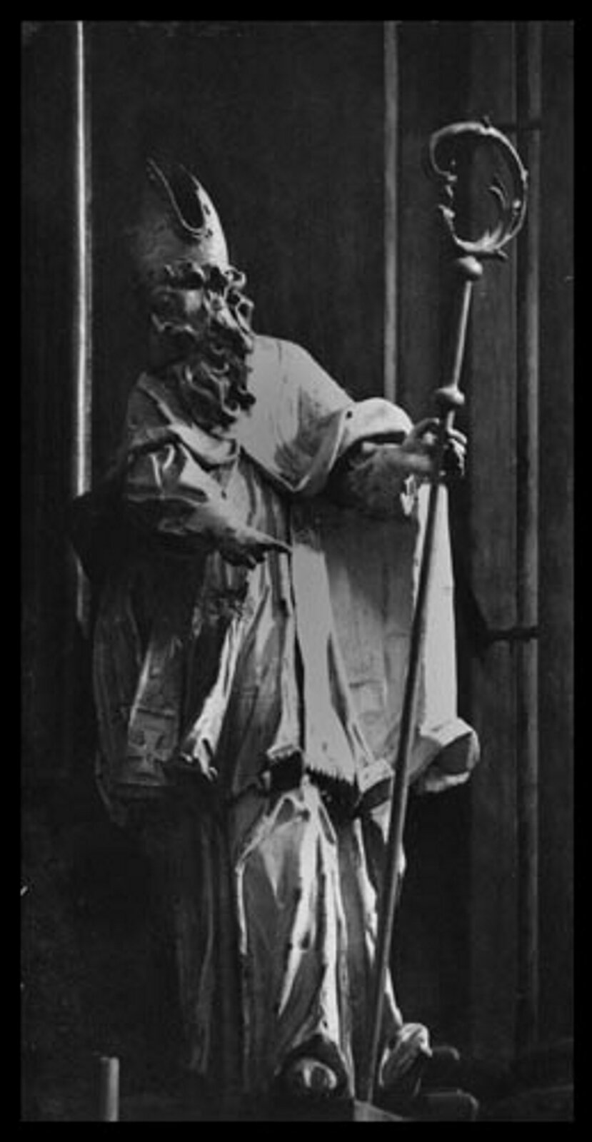 Ilustracja przedstawia rzeźbę świętego Atanazego na Ołtarzu Przemieniania Pańskiego we Lwowie. Rzeźba ukazuje postać starszego mężczyzny odzianego w długie szaty. Postać ma długie falowane włosy oraz bujny zarost. Na głowie założoną ma czapkę. W prawej dłoni trzyma laskę papieża, lewą zaś wskazuje przed siebie.
