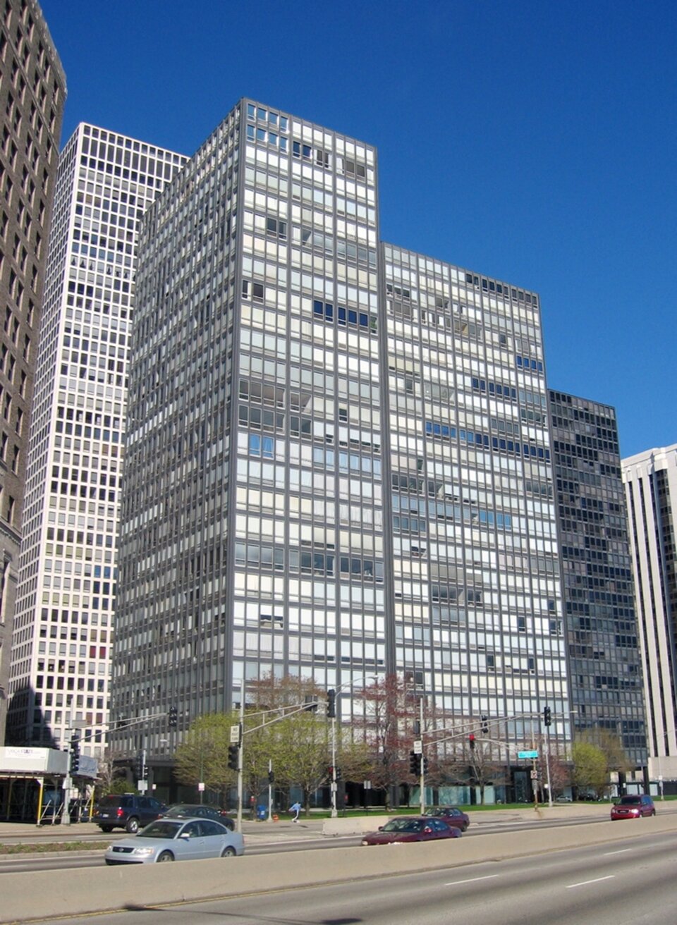 Ilustracja przedstawia budynki - apartamentowce 860‑880 w Chicago w USA. Są to wysokie, oszklone budowle. Prezentują styl międzynarodowy w architekturze.