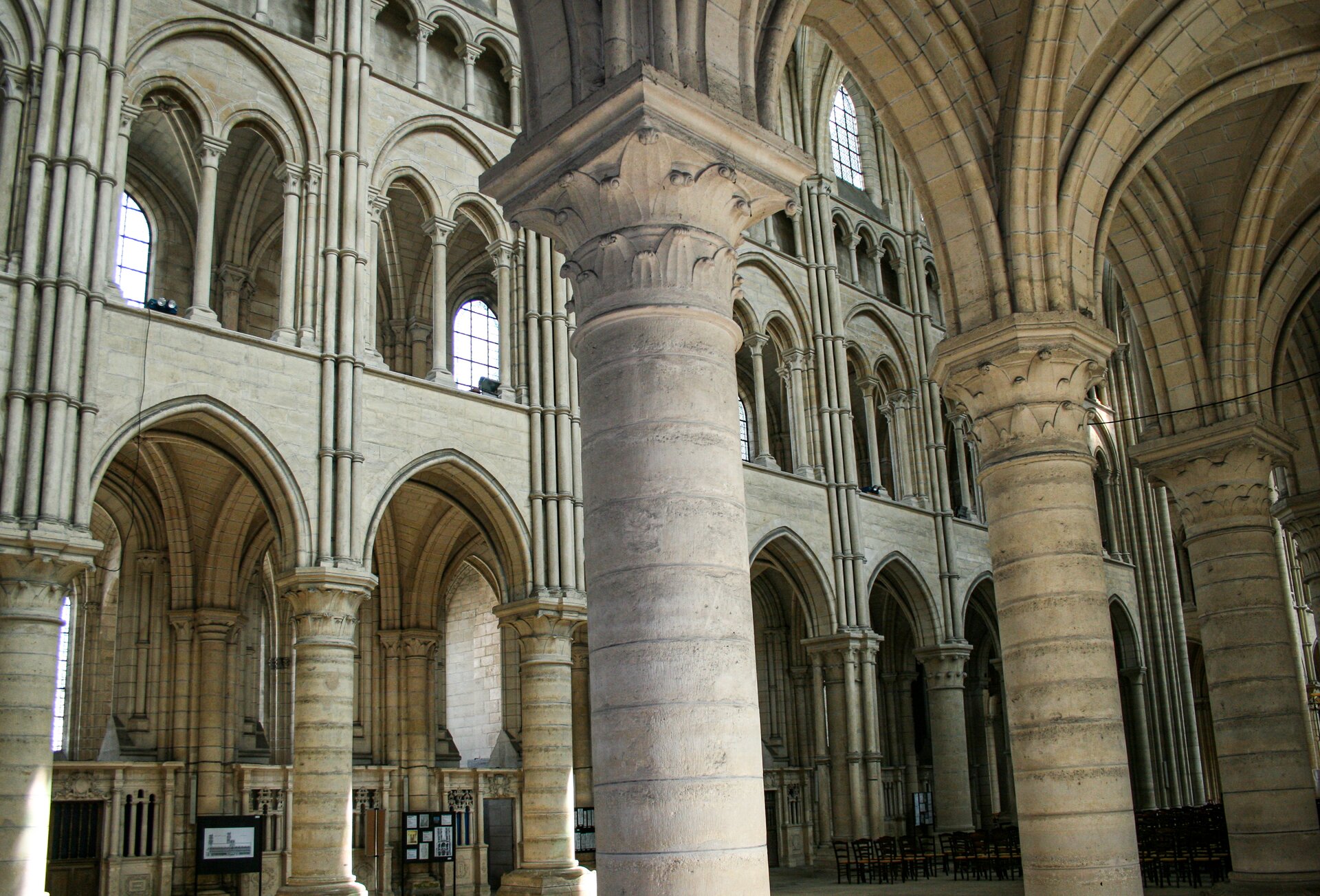 Fotografia przedstawia wnętrze katedry zbudowanej w stylu gotyckim. Ukazana jest główna nawa. Jest to wysokie pomieszczenie wsparte na licznych kolumnach zwieńczonych płaskorzeźbami z liśćmi akantu. Uwagę zwracają łuki różnych rozmiarów.