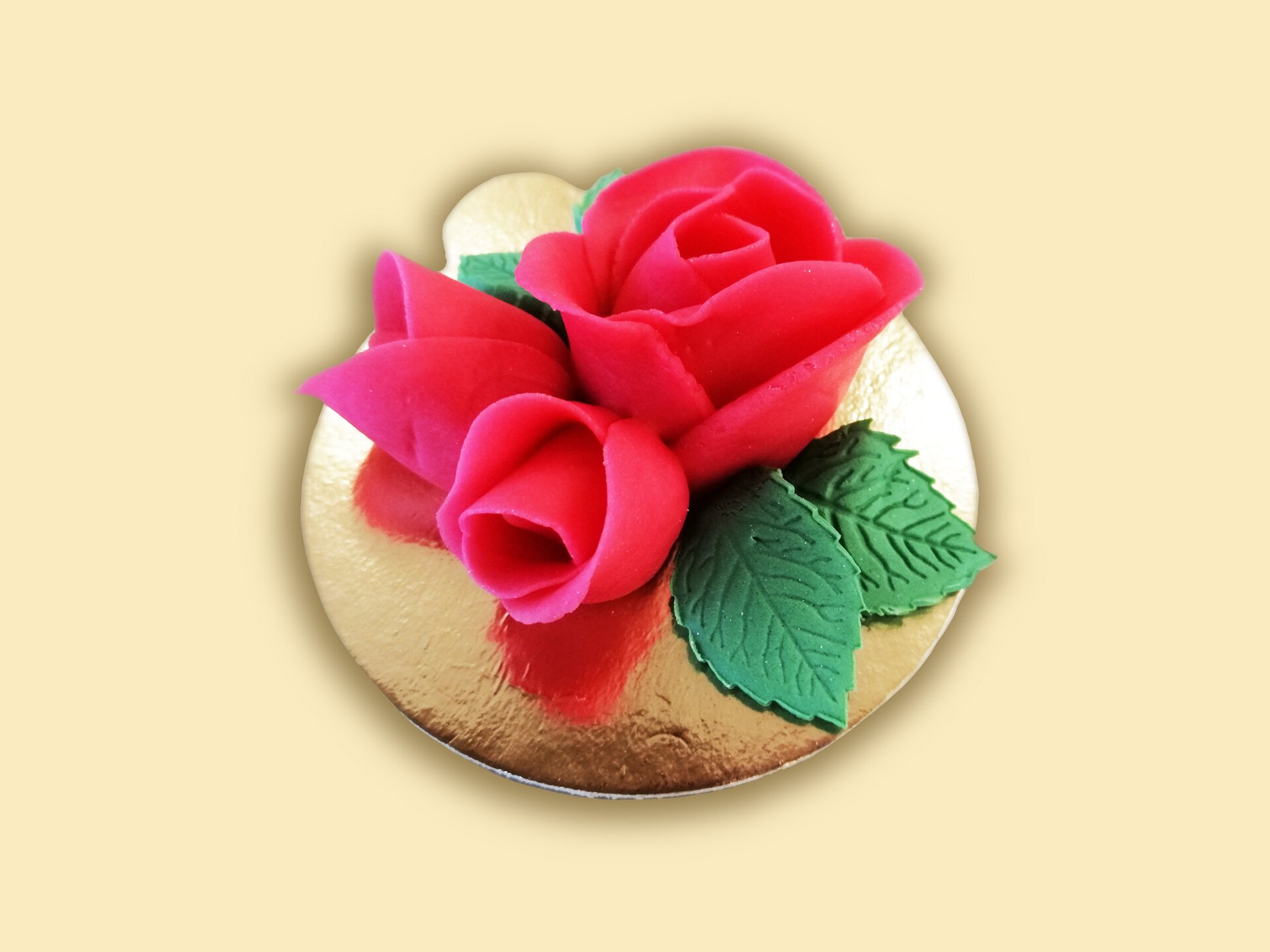 Zestaw trzech róż z masy cukrowej, wzbogaconych liśćmi.