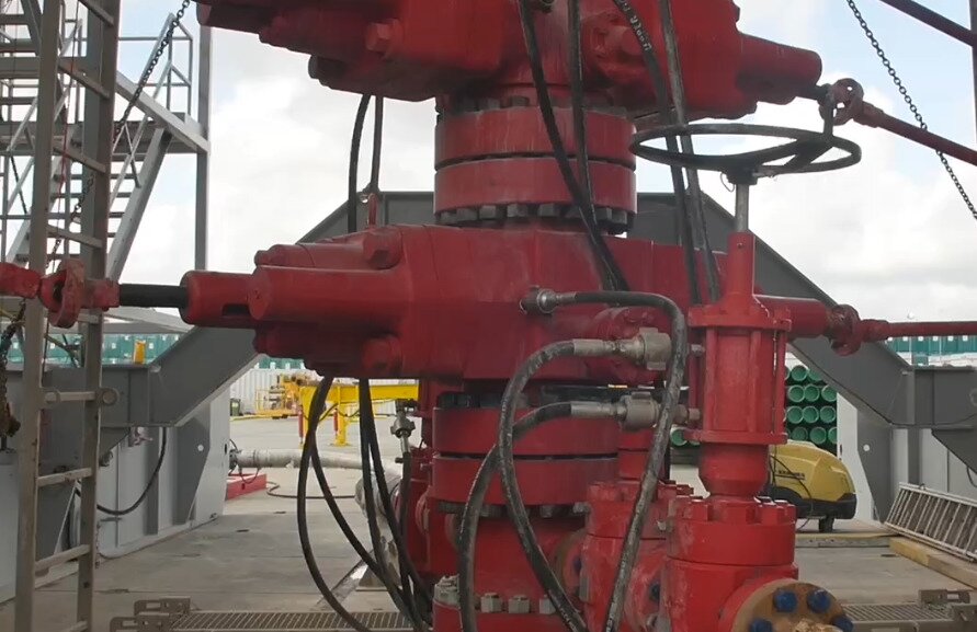 Na zdjęciu widoczna jest głowica przeciwerupcyjna szczękowa z pojedynczymi szczękami. Urządzenie jest przeznaczone do zamknięcia wylotu otworu wiertniczego przy wierceniach obrotowych w celu przeciwdziałania erupcji płynu złożowego. Urządzenie składa się z poziomego prostopadłościanu posiadającego z prawej i lewej strony walce, do których przyłączone są metalowe rury. Nad i pod prostopadłościanem znajduje się okrągły element łączący elementy wiertnicze.Poniżej zdjęcia w prawym dolnym rogu widoczny jest przycisk odtwarzania. Tekst nagrania jest zgodny z tytułem zdjęcia.