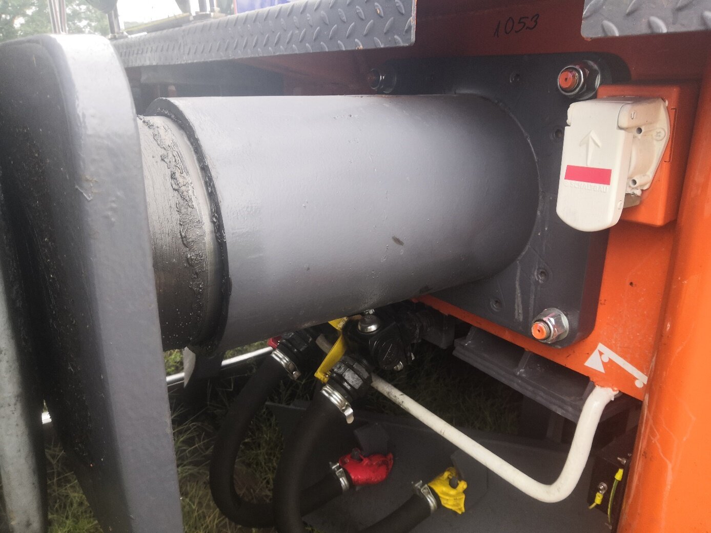 Zdjęcie przedstawia zderzak. Jest to cylinder przytwierdzony do wagonu za pomocą czterech śrub, wewnątrz którego jest drugi cylinder zakończony prostokątną płytą zderzaka.