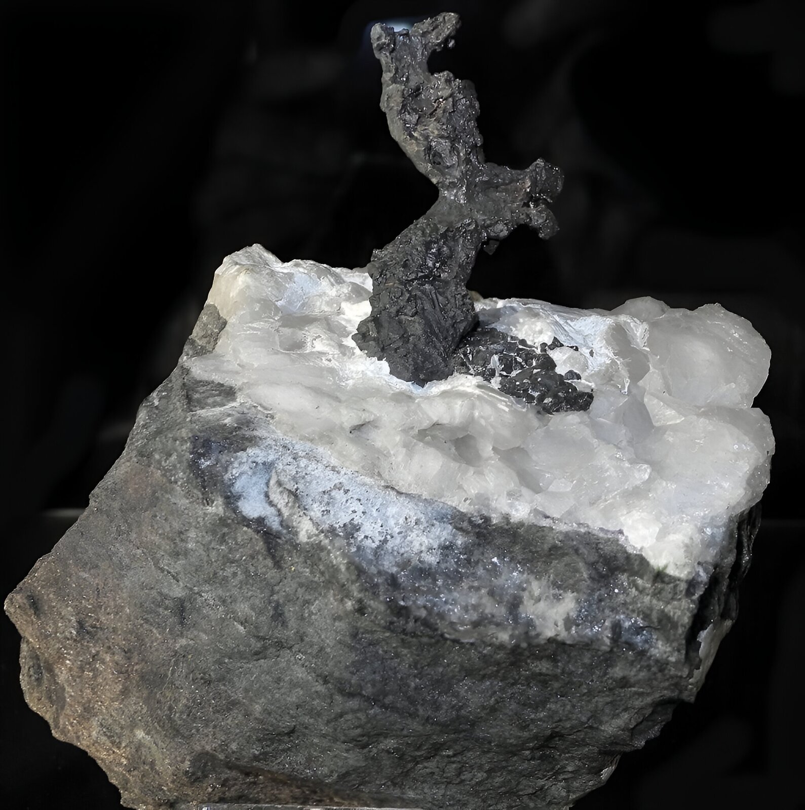 Zdjęcie przedstawia grudkę srebra na czarnym tle.