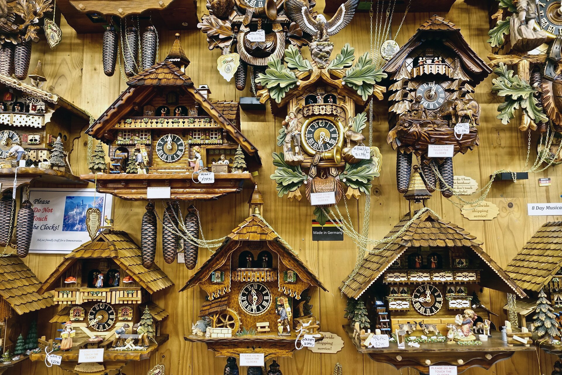 Rys. a. Zdjęcie przedstawia ścianę, na której zawieszonych zostało wiele starych drewnianych zegarów. Ściana, na której wiszą również jest drewniana. Na tarczy każdego zegara można odczytać godzinę. Zegary są bardzo ozdobne, wyglądają jak małe domki. Każdy z nich wyposażony jest w trzy metalowe odważniki przypominające szyszki. Podczas wybijania godziny, każdy zegar przedstawia unikalną scenkę z udziałem ruchomych, drewnianych postaci poruszających się na szynach wmontowanych w konstrukcję czasomierza. Każdy prezentowany na zdjęciu zegar wskazuje inną godzinę. Zegary, choć piękne posiadają pewną wadę, której konstruktorzy nie mogli uniknąć. Każdy z nich odmierza czas jedynie z pewną dokładnością. Żaden z mechanizmów nie jest pozbawiony wad, na które wpływa błąd systematyczny oraz błędy przypadkowe. Warto uświadomić sobie patrząc na pięknie zdobione zegary, że żaden pomiar, nie tylko czasu, nie jest wykonywany nieskończenie dokładnie.