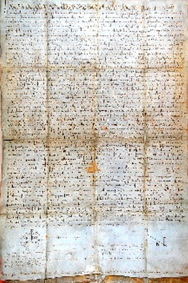 Zdjęcie przedstawia dużą kartę papieru. Jest ona zapisana odręcznie łacińskim pismem. Na karcie są zagniecenia od składania.