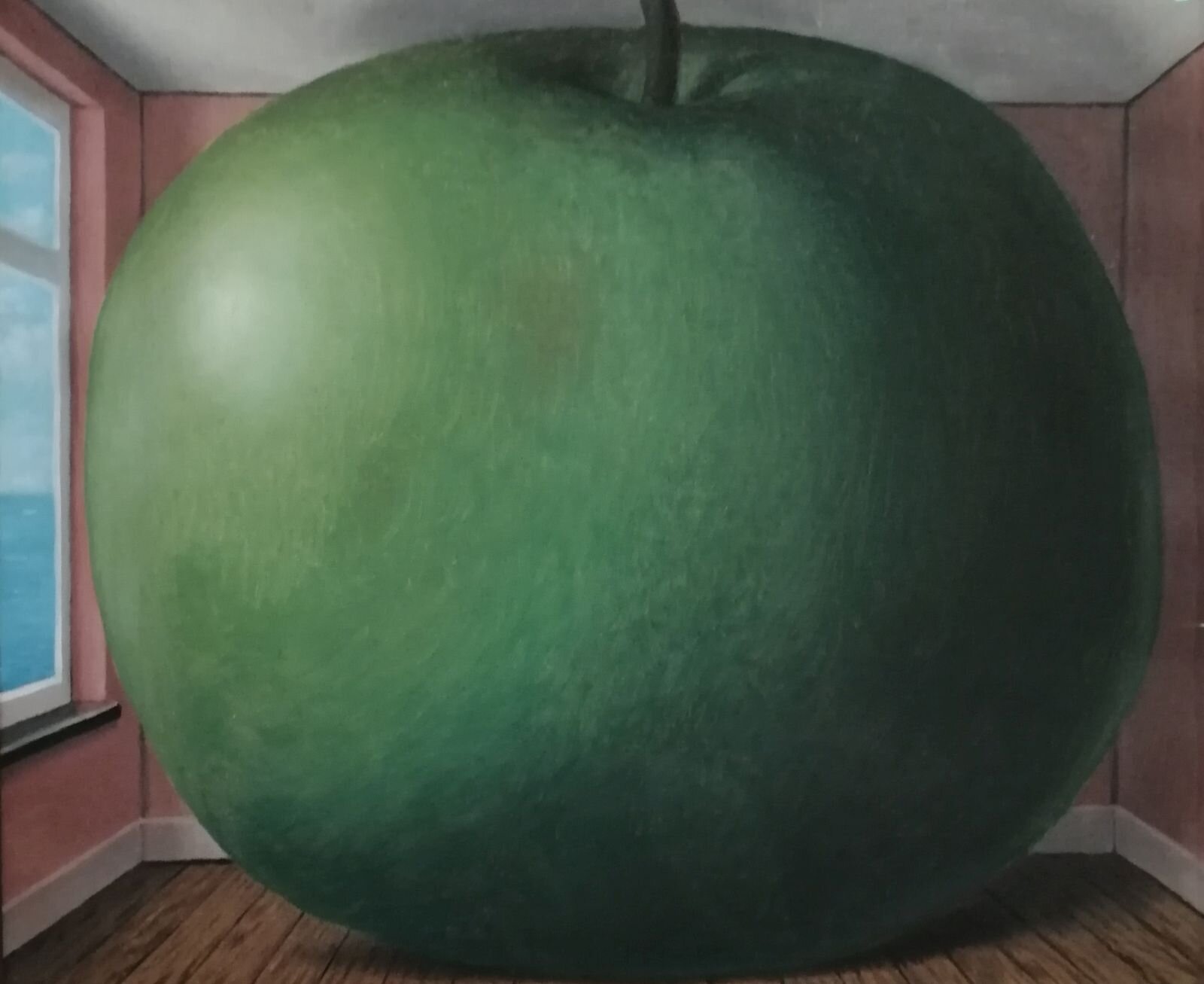 Obraz przedstawia wnętrze pokoju o białym suficie, różowych ścianach i drewnianej podłodze. Z lewej strony widać fragment okna. W pokoju znajduje się wielkie, zielone jabłko, które wypełnia całą przestrzeń pokoju. 