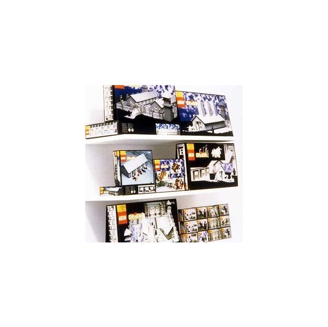 Zdjęcie przedstawia pudełka z klockami lego ustawione na trzech pułkach. Zestawy klocków służą do zbudowania elementów obozu koncentracyjnego. Pudełka wyglądają jak oryginalne zabawki firmy Lego.