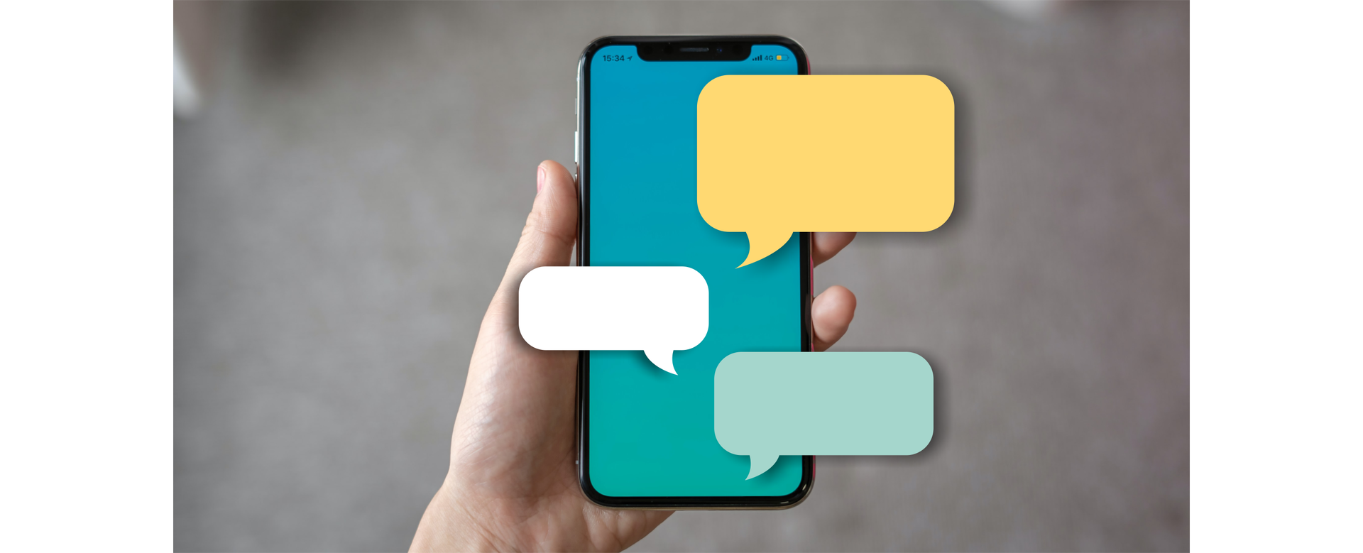 Zdjęcie przedstawia telefon komórkowy trzymany w dłoni. Na telefonie umieszczone są puste dymki.