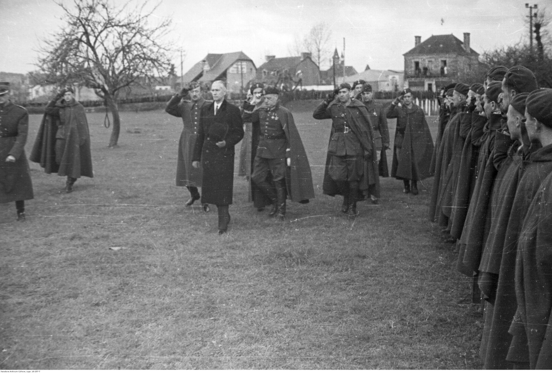 Zdjęcie przedstawia żołnierzy Samodzielnej Brygady Strzelców podhalańskich, którzy przyglądają się swoim dowódcom oraz prezydentowi Władysławowi Raczkiewiczowi. Dowódcy salutują, żołnierze stoją na baczność.