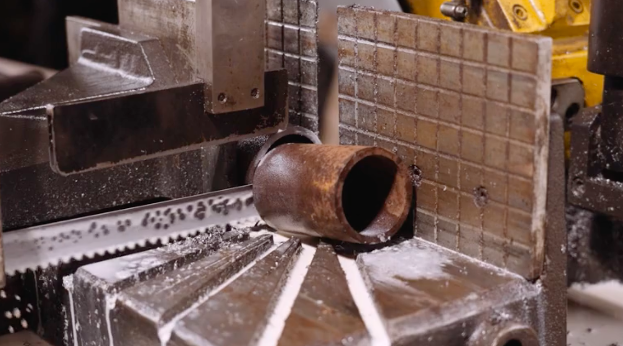 Na zdjęciu widoczna jest leżąca na przecinarce obrobiona rura stalowa o grubych ścianach. Poniżej ilustracji znajduje się przycisk do odtworzenia nagrania.