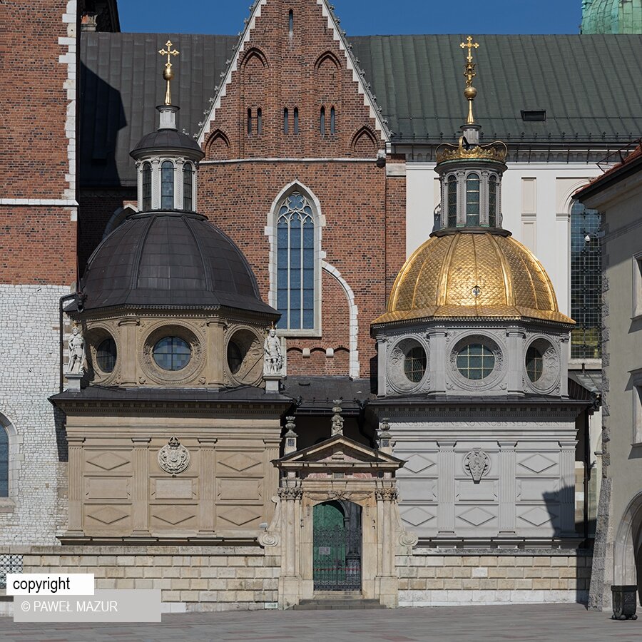 Zdjęcie przedstawia mur z niewielką furtką, za którą znajduje się wejście do kaplicy. Po obu stronach wejścia są niewysokie wieże zwieńczone kopułami z krzyżami. Za nimi znajduje się budynek kaplicy.