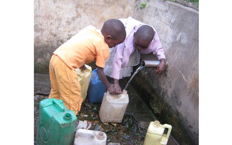 Zdjęcie przedstawia czarnoskóre dzieci wlewające wodę do kanistrów.