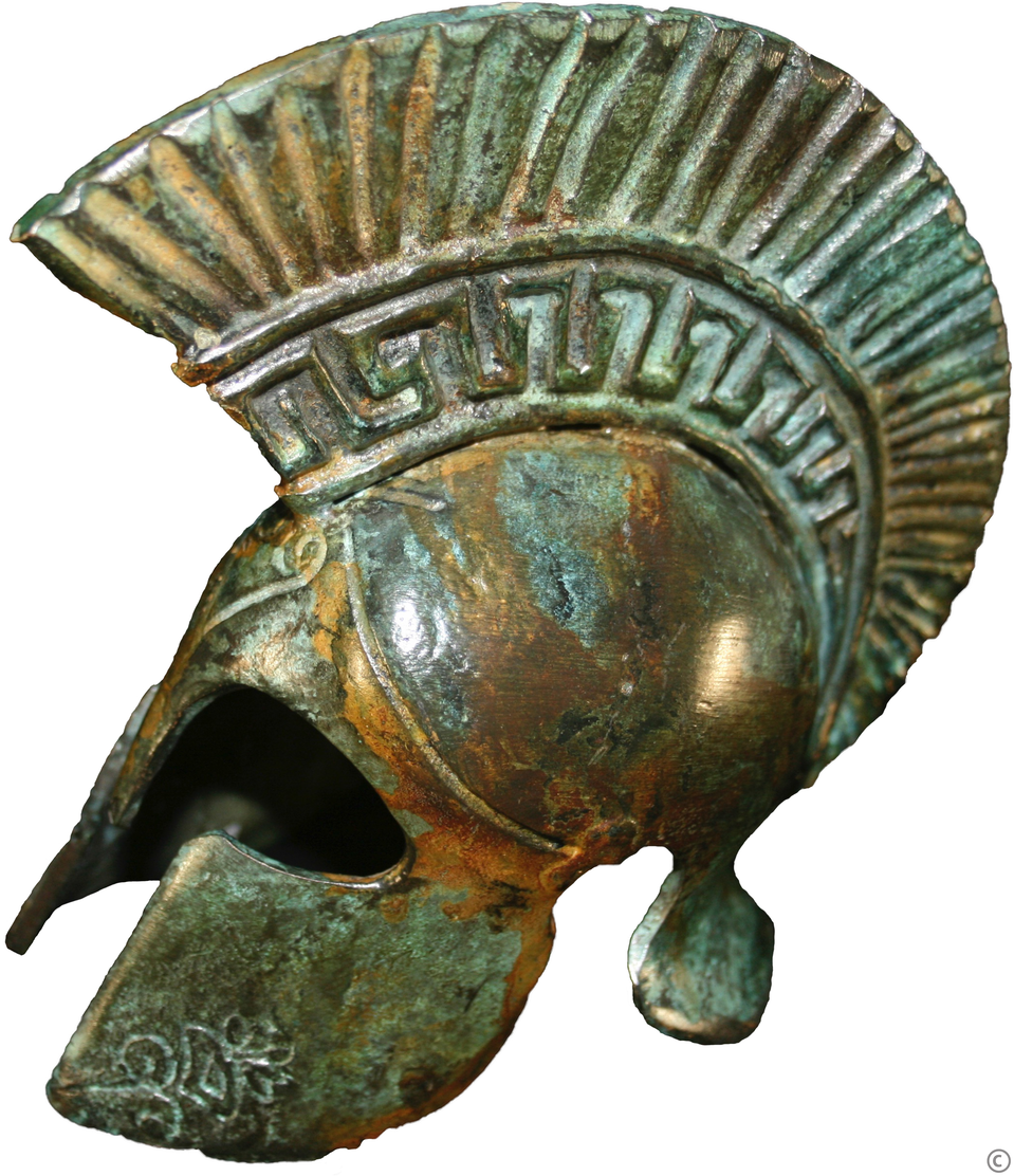 Zdjęcie przedstawia hełm metalowy z charakterystycznym grzebieniem idącym od otworu na oczy do tylnej krawędzi hełmu. Posiada on dwie zasłony na policzki złączone w korpusie hełmu oraz osłonę tyłu czaszki w formie płytki. Widok na hełm z profilu, otwór na oczy i twarz bliżej lewej krawędzi fotografii. Na grzebieniu widoczne fragmenty zdobień hełmu w postali falujących motywów geometrycznych. Widok współczesny na artefakt z licznymi przebarwieniami związanymi z upływem czasu.  
