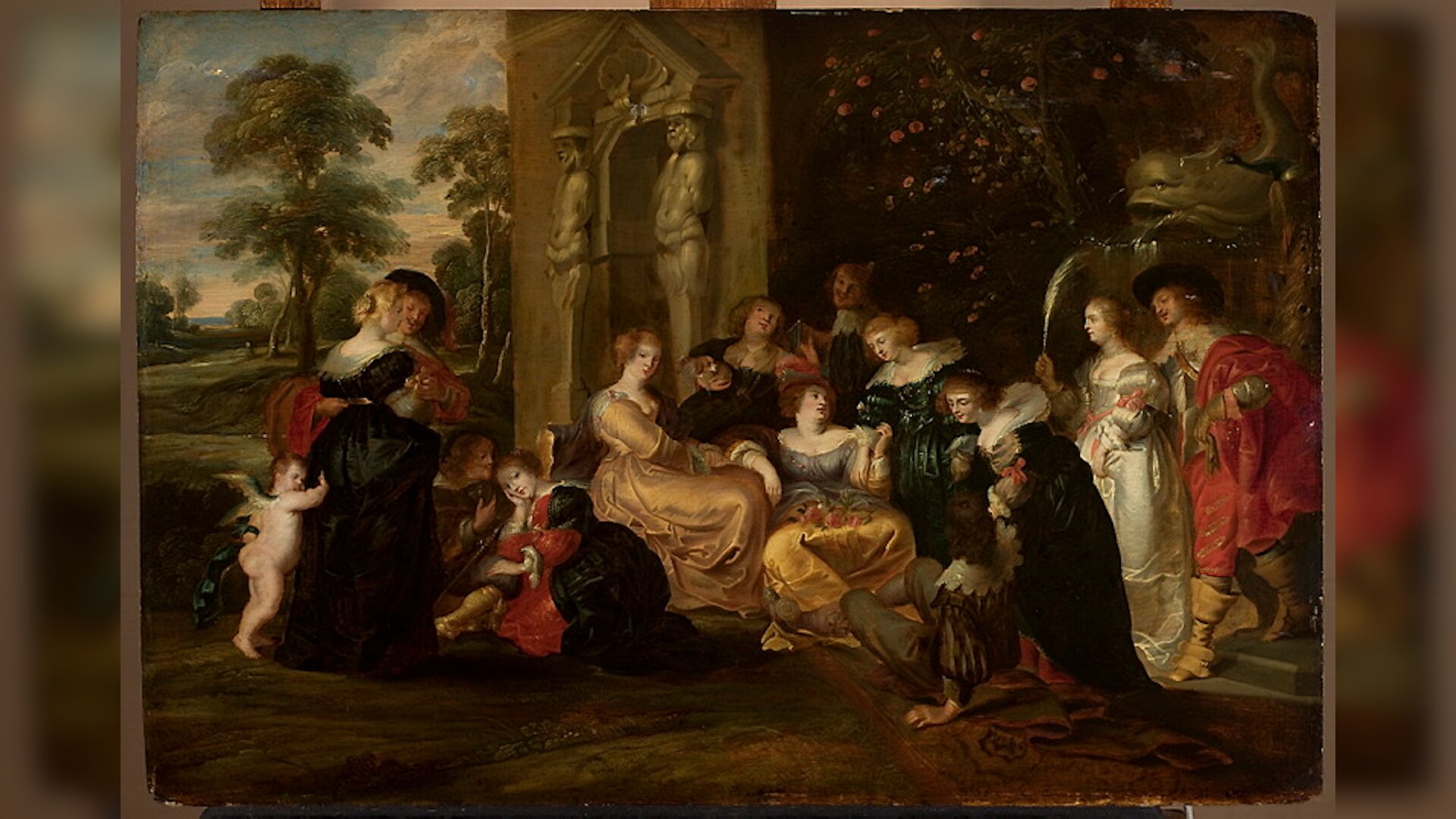 Obraz przedstawia scenę zbiorową. Grupa kobiet i mężczyzn w eleganckich strojach znajduje się w ogrodzie. Kobiety mają czarne i kolorowe suknie, a mężczyźni ciemne i kolorowe surduty. Postaci stoją i siedzą. Po lewej nagi aniołek trzyma się sukni kobiety. Na trawie leży rozłożony dywan. Po prawej za postaciami jest fontanna z rzeźbą ryby, pnącza z kwiatami i fragment budynku z wejściem, przy którym są płaskorzeźby ludzi. Po lewej w tle rosną drzewa i jest niebo z chmurami.