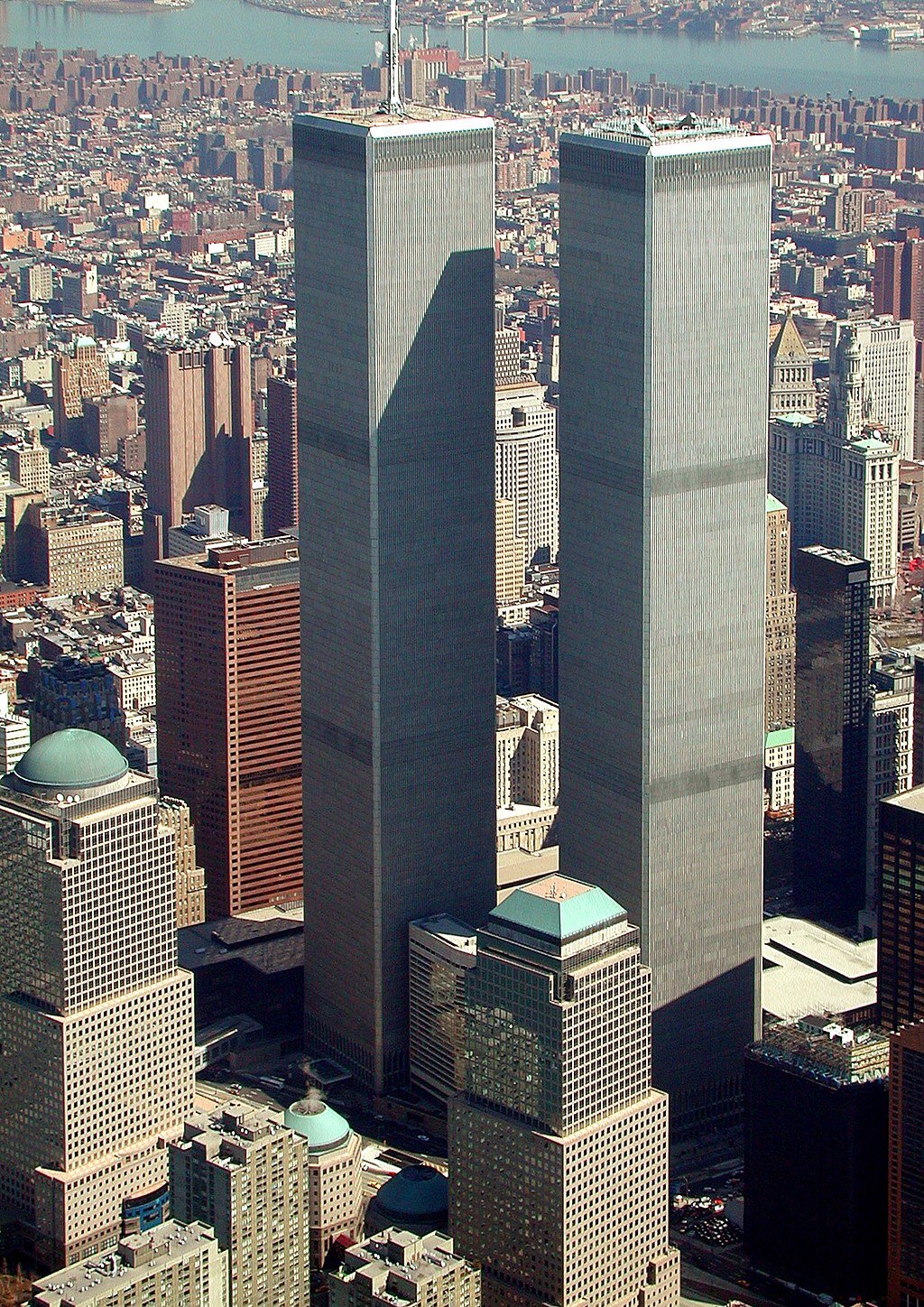 Zdjęcie przedstawia Manhattan z lotu ptaka. Na pierwszym planie znajdują się dwa identycznie wyglądające wieżowce. Górują one nad innymi budynkami. 