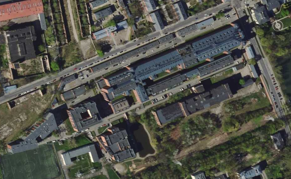 Ilustracja przedstawia zdjęcie z lotu ptaka na Lofty "U 
Scheiblera" w Łodzi. Są to luksusowe apartamenty w pobliżu zabytkowych fabryk i  domów robotniczych z XIX wieku. Są to podłużne budynki, są one regularnie rozłożone. 