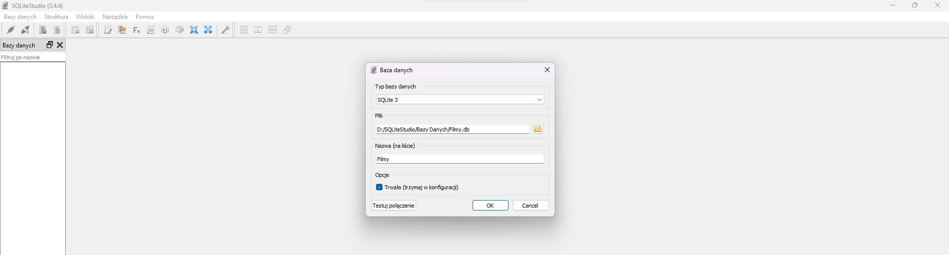 Na zdjęciu przedstawiono zrzut ekranu przedstawiający tworzenie nowej bazy danych w programie SQL lite Studio.W górnej części okna aplikacji widoczny jest pasek narzędzi z następującymi opcjami: bazy danych, struktur, widoki, narzędzia, pomoc. Poniżej paska narzędzi znajdują się ikony. Ikony przedstawiają w kolejności: zapięte wtyczki, rozpięte wtyczki, serwer z zielonym znakiem plus, serwer z dwoma zielonymi strzałkami, bazę danych ze znakiem plus, bazę danych ze znakiem plus i błyskawicą, kartkę papieru z ołówkiem, serwer z dłonią trzymającą kartkę, Fx, kartka z dwoma nawiasami ostrymi skierowanymi na zewnątrz, element z literami AZ, klocek dwa na dwa, cztery strzałki w układzie kwadratu skierowane do wewnątrz, cztery strzałki w układzie kwadratu skierowane na zewnątrz, klucz, cztery kwadraty w układzie kwadratu, dwa podłużne pionowe prostokąty obok siebie, dwa podłużne poziome prostokąty obok siebie, trzy okna ustawione jedno za drugim. Poniżej aplikacja podzielona jest na dwa obszary. Małe okno po lewej stronie ma tytuł: Bazy danych. Obok tytułu znajduje się znak powiększenia okna oraz zamknięcia. Poniżej znajduje się pole wyszukiwania. Na polu widoczny jest napis: filtruj po nazwie.W prawej części okna znajduje się właściwy obszar roboczy.W centralnej części obszaru roboczego znajduje się okno dialogowe baza danych. W oknie tworzenia znajdują się następujące pola Typ bazy danych, plik nazwa na liście. W polu typ bazy danych widoczny jest napis: SQL lite 3. W polu plik wpisana jest ścieżka dostępu bazy danych. W polu nazwa wpisany jest wyraz: filmy. Na dole znajduje się pole wyboru: opcje. W polu zaznaczona jest opcja: trwała trzymaj w konfiguracji. Na dole widoczne są przyciski: testuj połączenie, ok, cancel. 