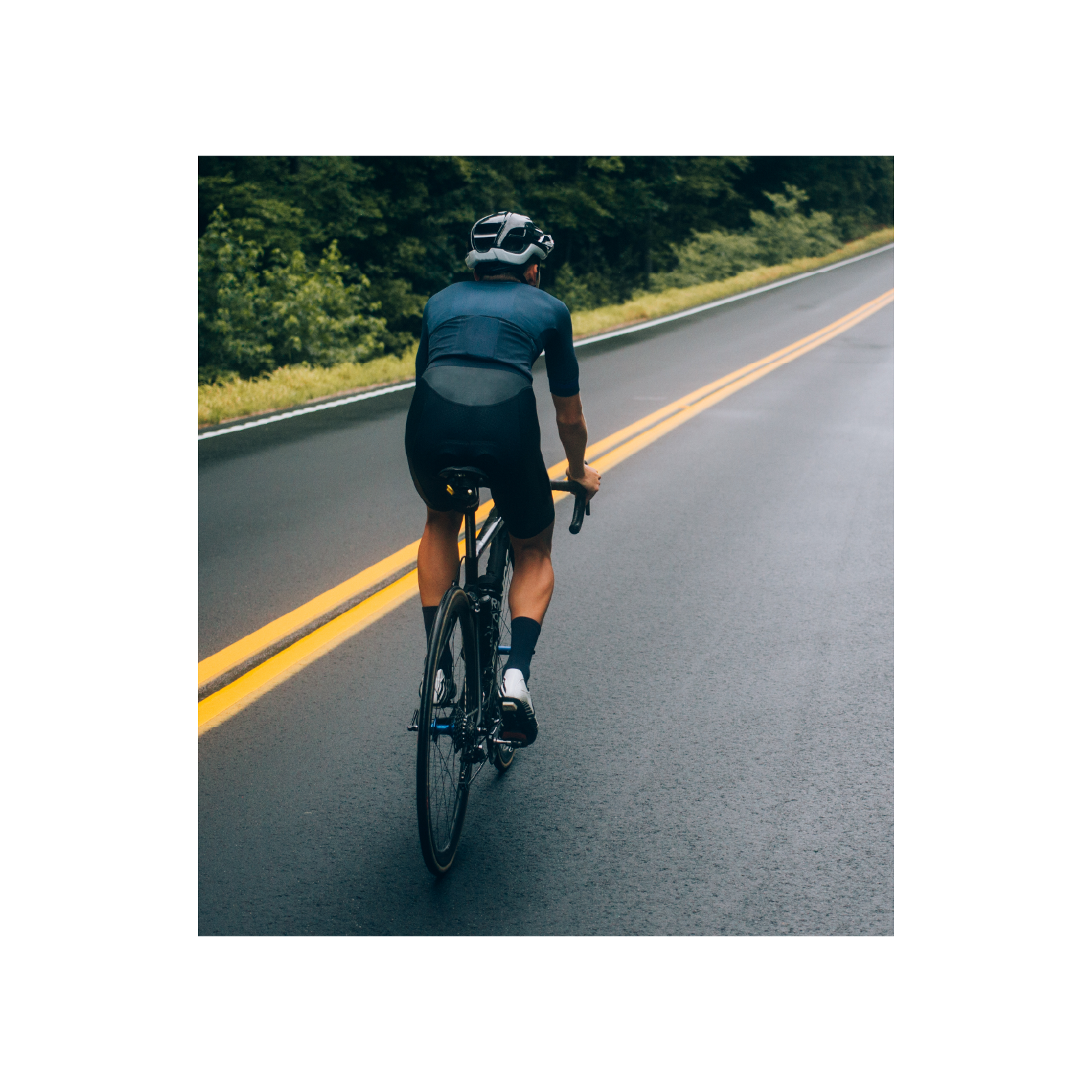 Zdjęcie przedstawia osobę jadącą szosą na rowerze. 