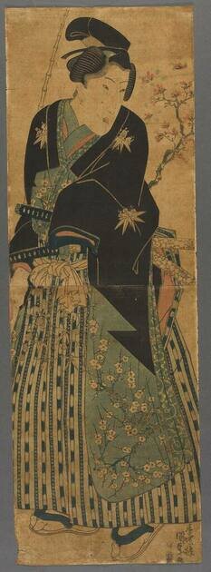 Rysunek przedstawia postać samuraja. Twarz ma pociągłą, włosy zaczesane i spięte u góry. Ubrany jest w szeroki, długi strój przewiązany w pasie. Na nogach ma założone japonki.