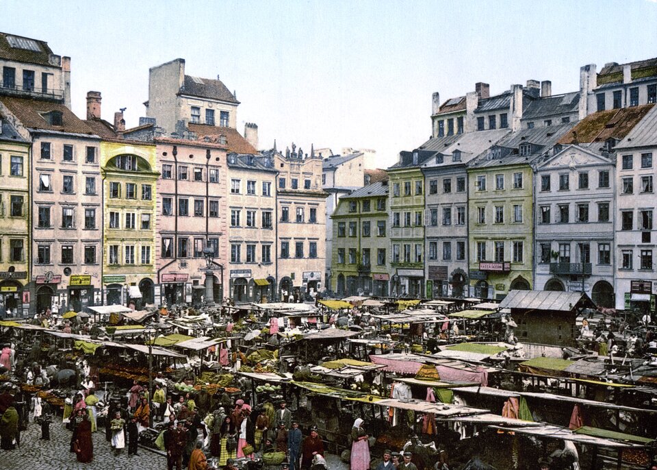 Na ilustracji znajduje się prostokątny plac otoczony z każdej strony kamienicami (widoczne dwie prostopadłe do siebie pierzeje), na pierwszym planie, na placu, gęsto ustawione stragany, wokół których są ludzie.