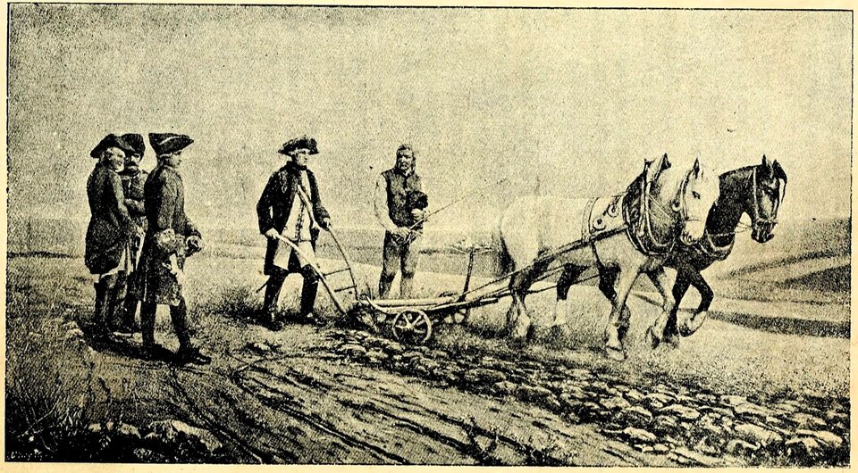 Rycina przedstawia Józefa II orzącego osobiście pole. Król trzyma w rękach pług ciągnięty przez dwa konie. Przygląda się temu trzech żołnierzy i chłop z batem w dłoni.