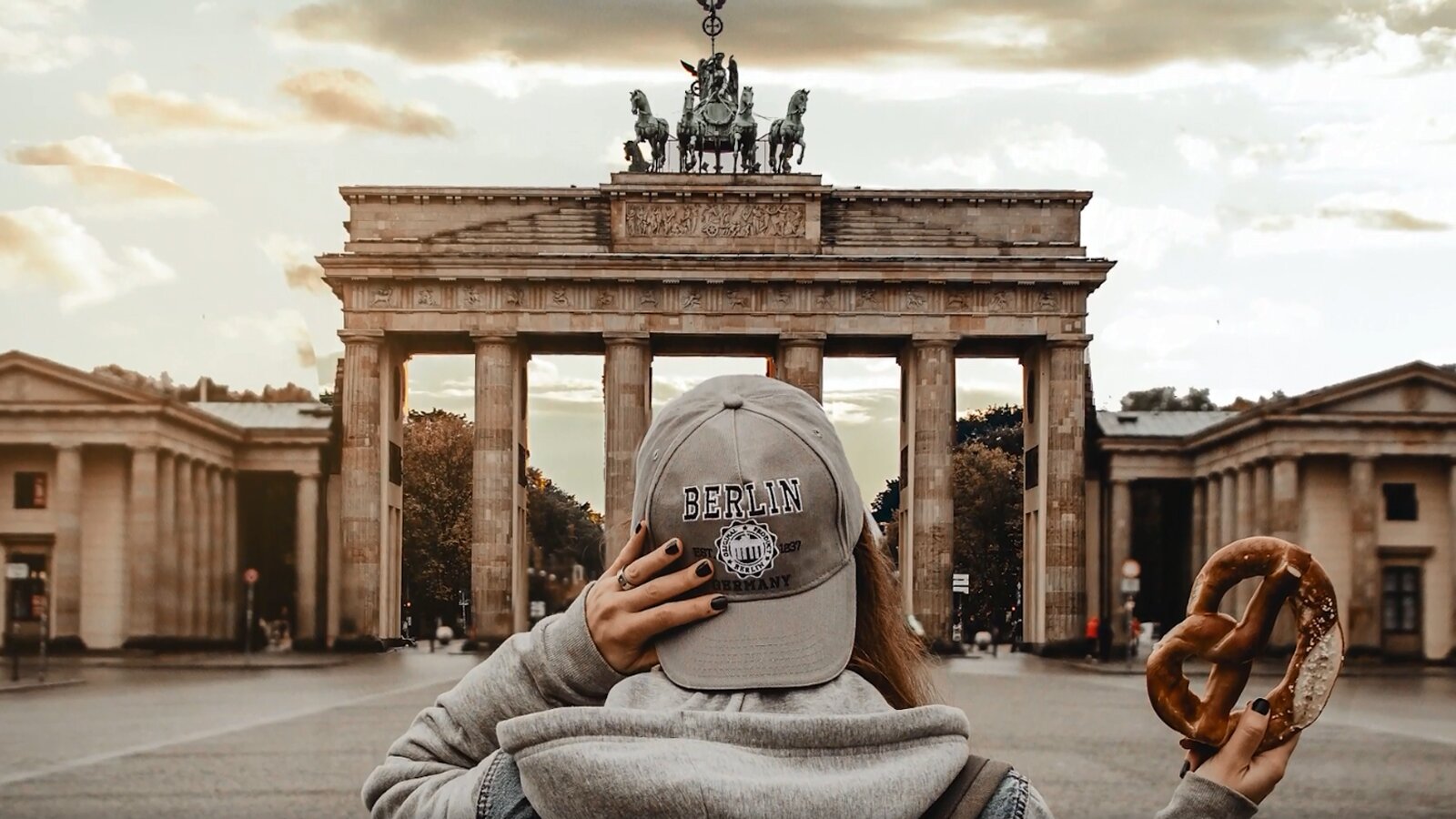   Wenn du die genannten Ratschläge in deinen Sprachalltag integrierst, wirst du sicherlich schnell dein Sprachniveau steigern. Aber nicht vergessen! Das Allerwichtigste ist, sowohl beim Lernen als auch beim Sprechen jede Menge Spaß zu haben.
Tue deshalb nichts, was dir nicht gefällt oder was du langweilig findest.
12. Fazit
Wenn du die genannten Ratschläge in deinen Sprachalltag integrierst, wirst du sicherlich schnell dein Sprachniveau steigern. Aber nicht vergessen! Das Allerwichtigste ist, sowohl beim Lernen als auch beim Sprechen jede Menge Spaß zu haben.
Opis: Na pierwszym widoczna jest kobieta w czapce z daszkiem I preclem w dłoni, która przygląda się monumentalnej konstrukcji w kształcie triumfalnej bramy, z pięcioma przejściami. Ozdobiona jest kolumnami i rzeźbami. Na szczycie znajduje się czterokonny rydwan z wozem triumfalnym w którym siedzi postać męska.
