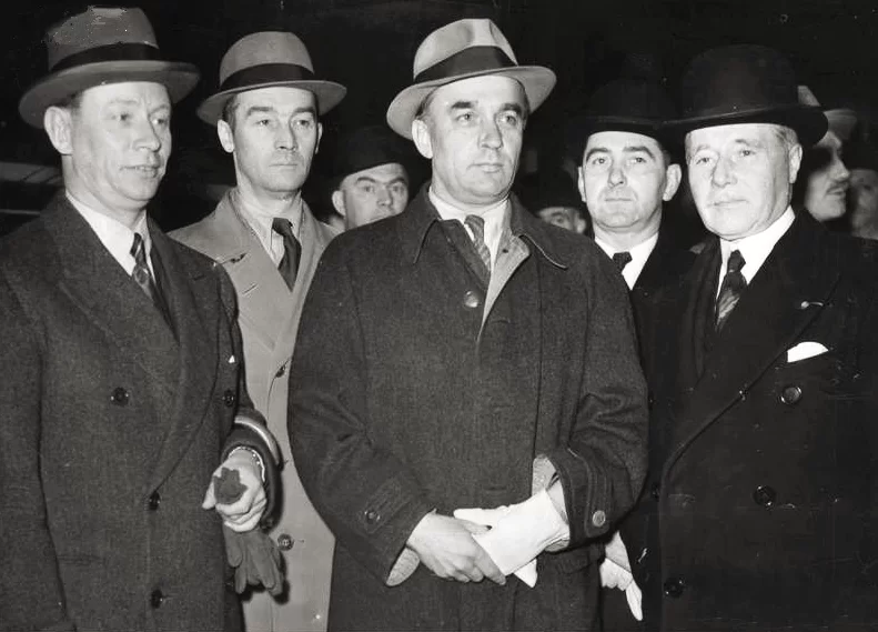 Zdjęcie przedstawia Juliusza Łukasiewicza, ambasadora RP we Francji, gen. Tadeusza Kasprzyckiego, ministra spraw wojskowych RP i gen. Maurice Gamelina, naczelnego dowódcy sił francuskich. Mężczyźni stoją obok siebie ubrani w eleganckie płaszcze, na głowach mają kapelusze. 