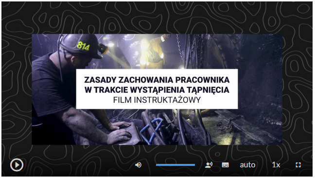 Na zdjęciu widoczny jest przykładowy kadr filmu na którym znajduje się plansza tytułowa.W centralnej części zdjęcia widoczny jest tytuł filmu. Przykładowo: Zasady zachowania pracownika w trakcie wystąpienia tąpnięcia, film instruktażowy. Pod planszą widoczna jest grafika. Na zdjęciu znajduje się górnik ubrany w kask z czołówką który opiera ręce na metalowej obudowie urządzenia. Z prawej strony zdjęcia widać fragment ociosu.Poniżej w lewym dolnym rogu ekranu widoczny jest przycisk z symbolem trójkąta umożliwiający uruchamianie lub zatrzymywanie filmu. W prawym dolnym rogu ekranu znajdują się przyciski służące a do odtwarzania filmu. Kolejną są to regulacja głośności oznaczona symbolem głośnika, ustawienie tekstu, tryb auto, prędkość odtwarzania oraz możliwość powiększenia ekranu.