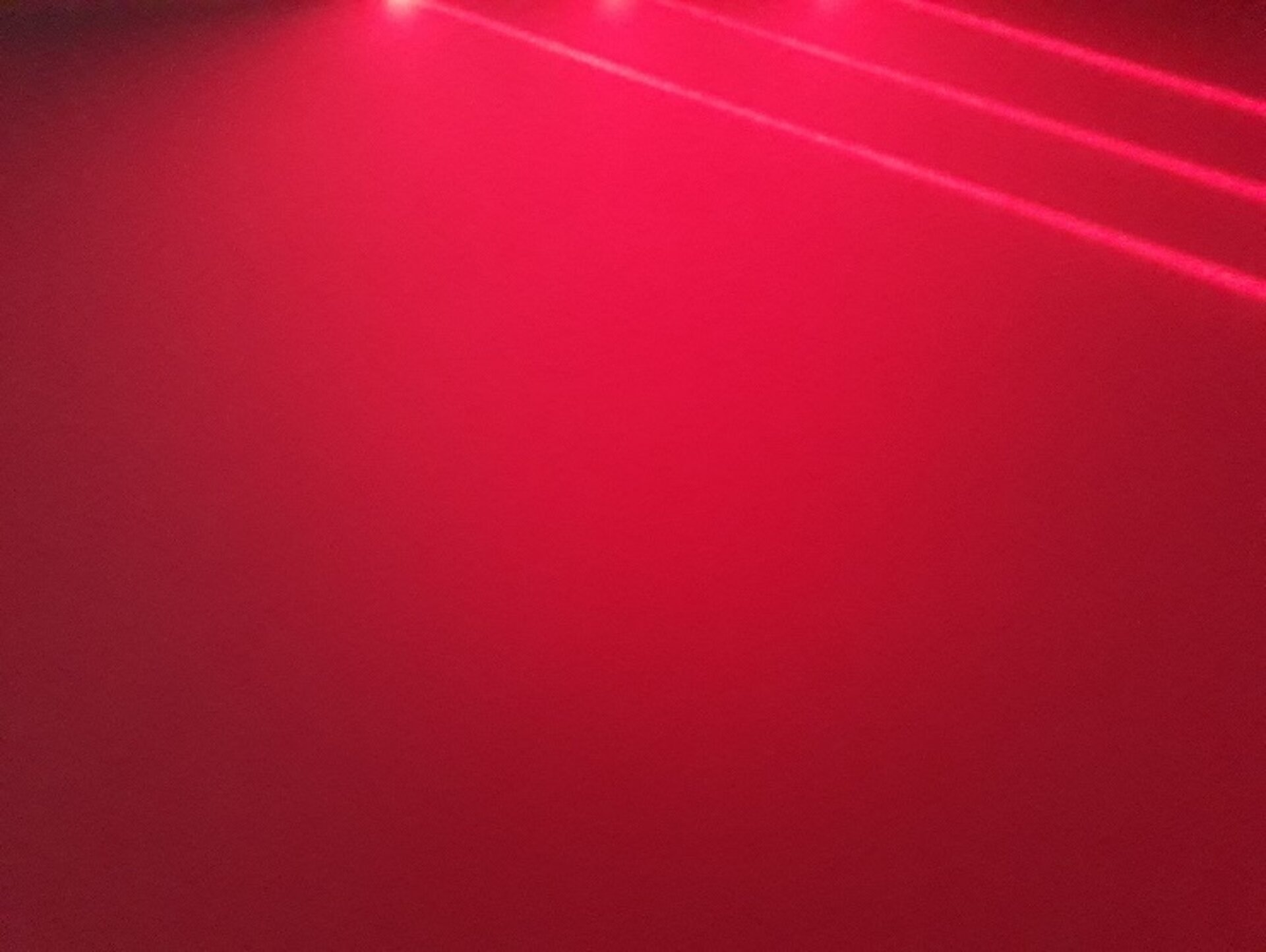 Ilustracja demonstruje, jak światło lasera padając na powierzchnię chropowatą ulega rozproszeniu. Brak tym razem wyraźnych linii lasera, całe zdjęcie stanowi właściwie czerwony prostokąt, lekko pocieniowany z rozmytymi trzema równoległymi wiązkami lasera w prawym górnym rogu. 