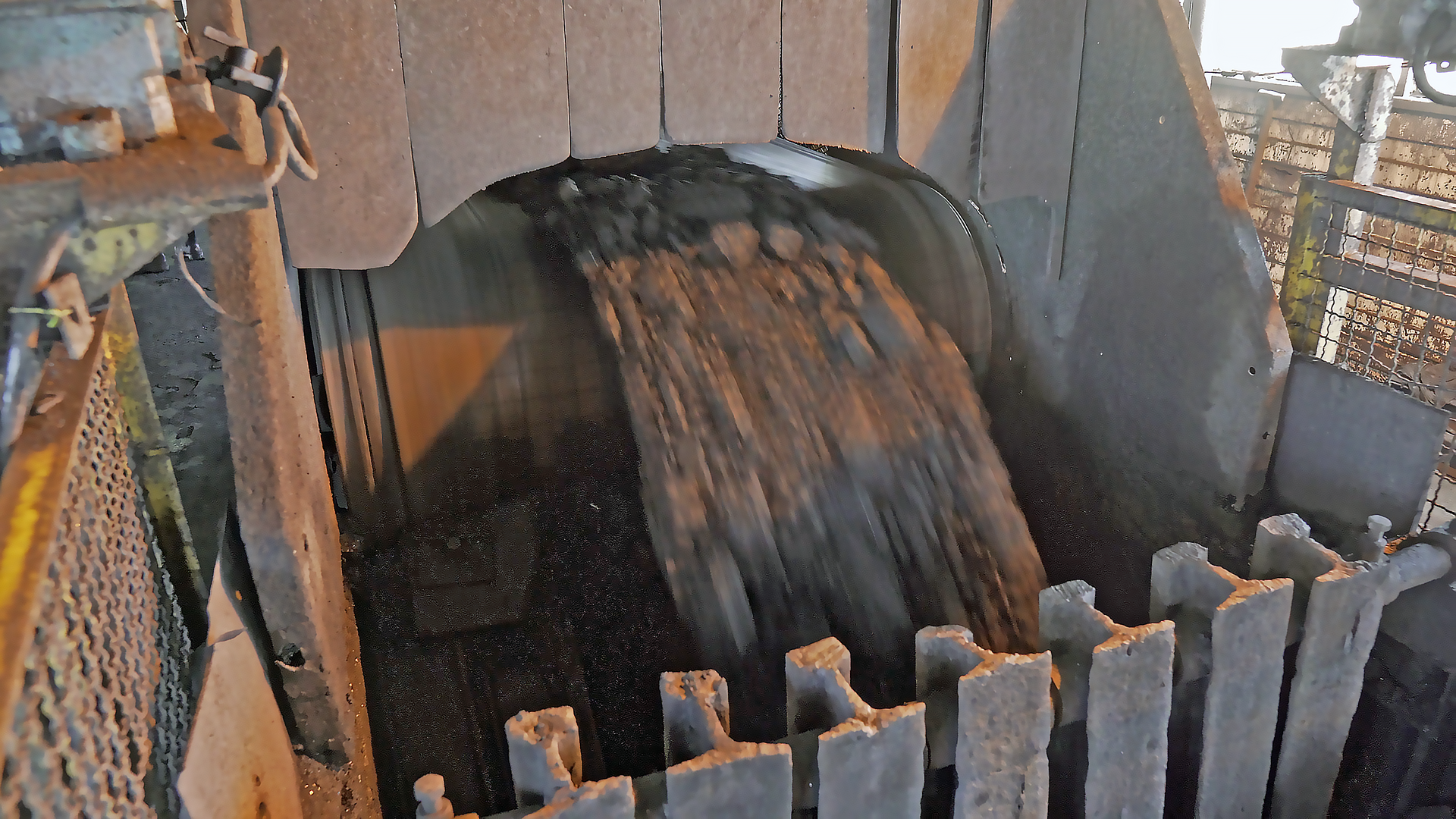 Na zdjęciu widoczny jest węgiel zrzucany z przenośnika taśmowego. W centralnym elemencie zdjęcia widoczny jest walec na który nawijana jest rolka. Z przenośnika zrzucany jest węgiel. W dolnej części zdjęcia widoczne są zabezpieczenia zabezpieczające przed wydostawaniem się drobin z przenośnika. Zabezpieczenia przypominają metalowe sztachety.