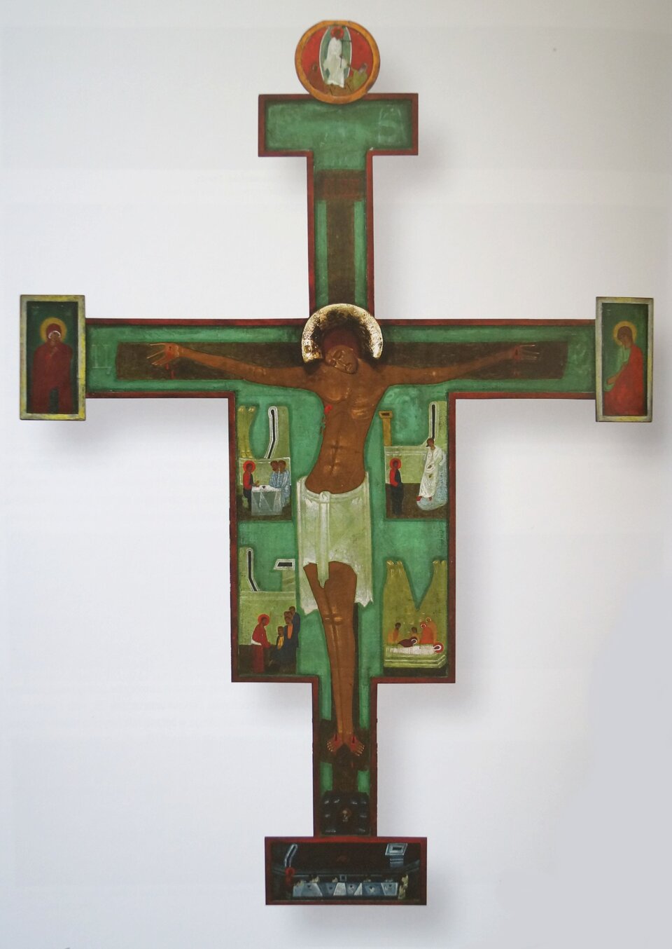 Obraz przedstawia wizerunek ukrzyżowanego Chrystusa. Krucyfiks zawiera również sceny z  życia Chrystusa oraz przedstawienia Marii i Jana Ewangelisty, zamieszczone na krawędziach poprzecznego ramienia krzyża. W centrum artysta namalował krzyż z wydłużoną i lekko wygiętą, schematyczną sylwetką Chrystusa o ciemnobrązowym ciele. Wnętrze krzyża ma kolor zielony. Krucyfiks, został zaprezentowany na białym tle.
