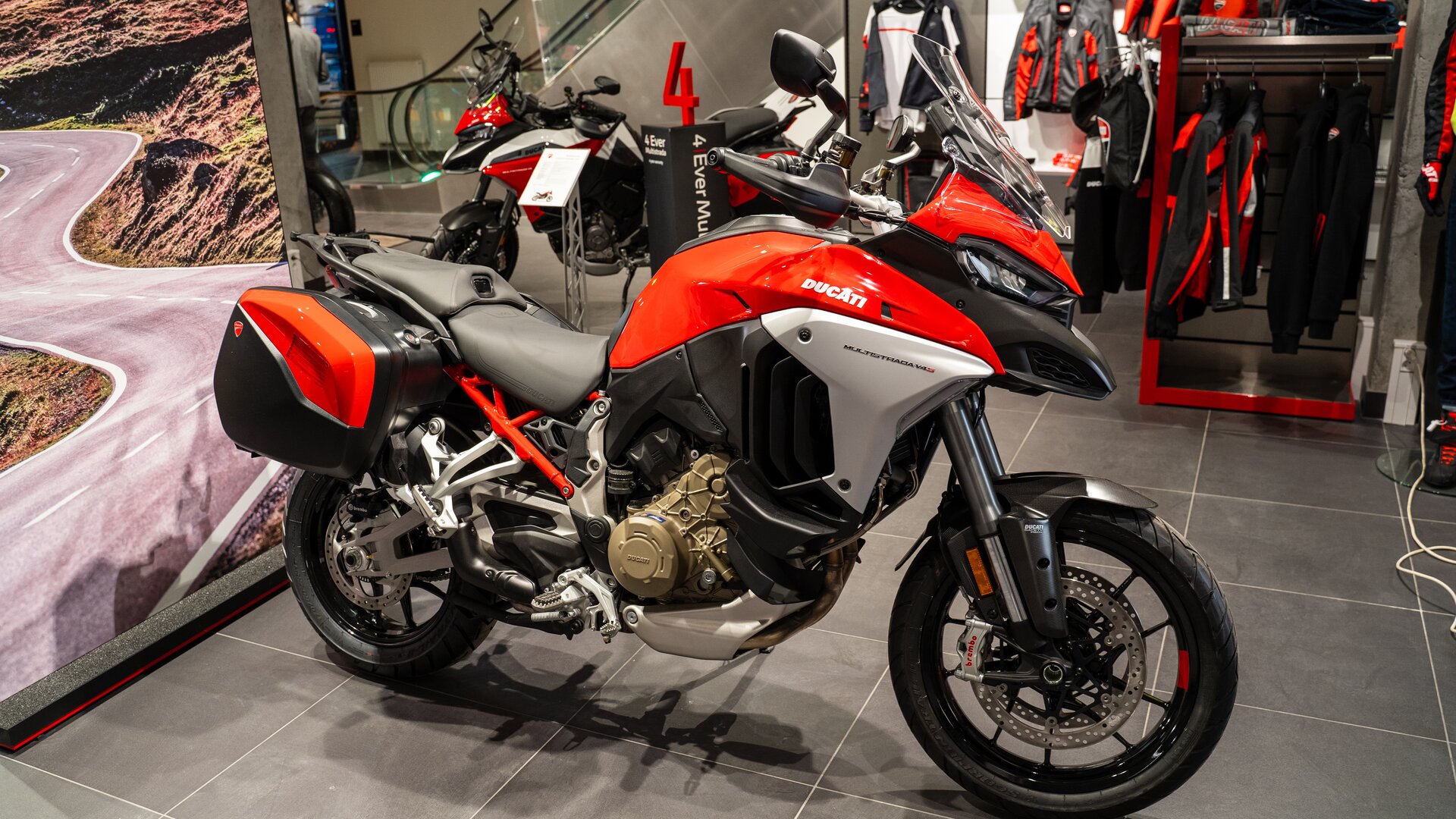 Zdjęcie przedstawia motocykl o zwartej konstrukcji. Koła mają dużą średnicę, opony są grube. Pojazd posiada osłony. Na wysokości tylnego koła po dwóch stronach są pojemniki - bagażnik. Motocykl ma rozbudowaną szybą czołową i częściową owiewkę łączącą się ze zbiornikiem paliwa. 