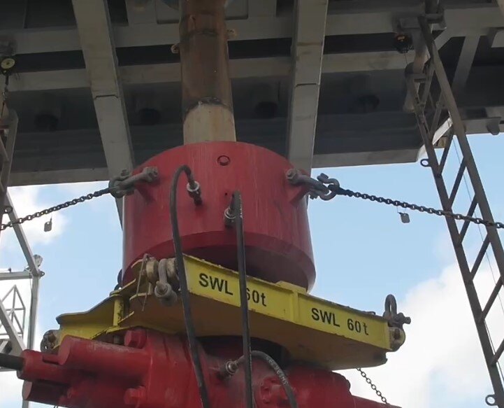 Na zdjęciu widoczna jest głowica przeciwerupcyjna uniwersalna. Urządzenie jest przeznaczone do zamknięcia wylotu otworu wiertniczego przy wierceniach obrotowych w celu przeciwdziałania erupcji płynu złożowego. Urządzenie kształtem przypomina sporej wielkości walec. Pod walcem znajduje się platforma z informacją o nośności sześćdziesięciu ton. Do głowicy przymocowane są łańcuchy. Nad głowicą widoczny jest wychodzący z niej przewód wiertniczy.Poniżej zdjęcia w prawym dolnym rogu widoczny jest przycisk odtwarzania. Tekst nagrania jest zgodny z tytułem zdjęcia.