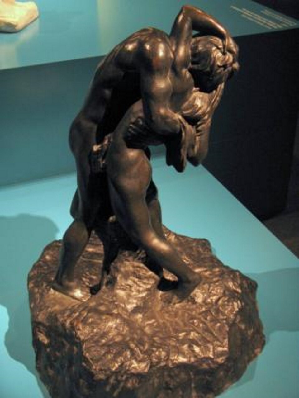 Ilustracja przedstawia rzeźbę pt. „Na skale” autorstwa Franciszka Flauma.  Rzeźba ukazuje scenę erotyczną przytulających i całujących się kochanków.