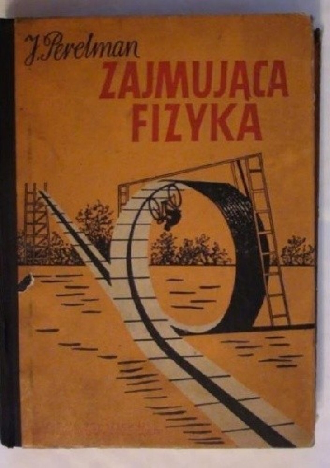 Na zdjęciu przedstawiono archiwalną okładkę książki autorstwa Jakowa Perelmana pt.: Zajmująca fizyka. Na okładce pokazano tzw. „diabelską pętlę”, w której rowerzysta jeździ głową w dół i nie spada z roweru.