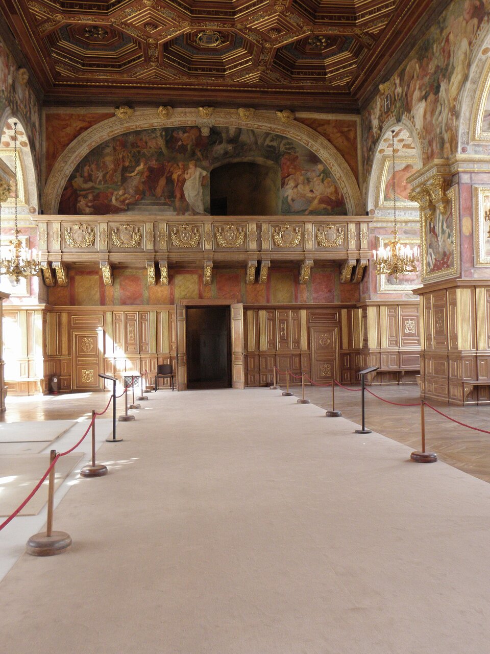 Ilustracja o kształcie pionowego prostokąta przedstawia wnętrze sali balowej z dekoracjami malarskimi Francesca Primaticcia. Na fotografii ujęte jest wejście do pomieszczenia, nad którym znajduje się balkon. Nad nim widoczne są freski, zamieszczone w podłużnym polu, zwieńczonym półkolistym łukiem. Sufit dekorowany jest ośmiokątnymi kasetonami z obramieniem.   Ściany boczne z łukami i filarami dekorują freski. 