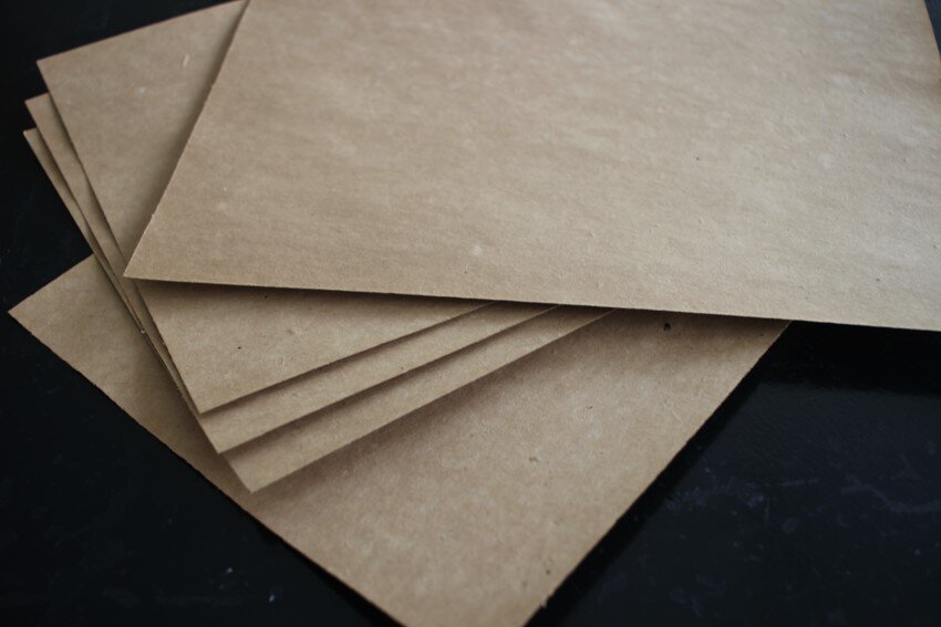 Zdjęcie przedstawia kilka arkuszy brązowego papieru o podwyższonej gramaturze.
