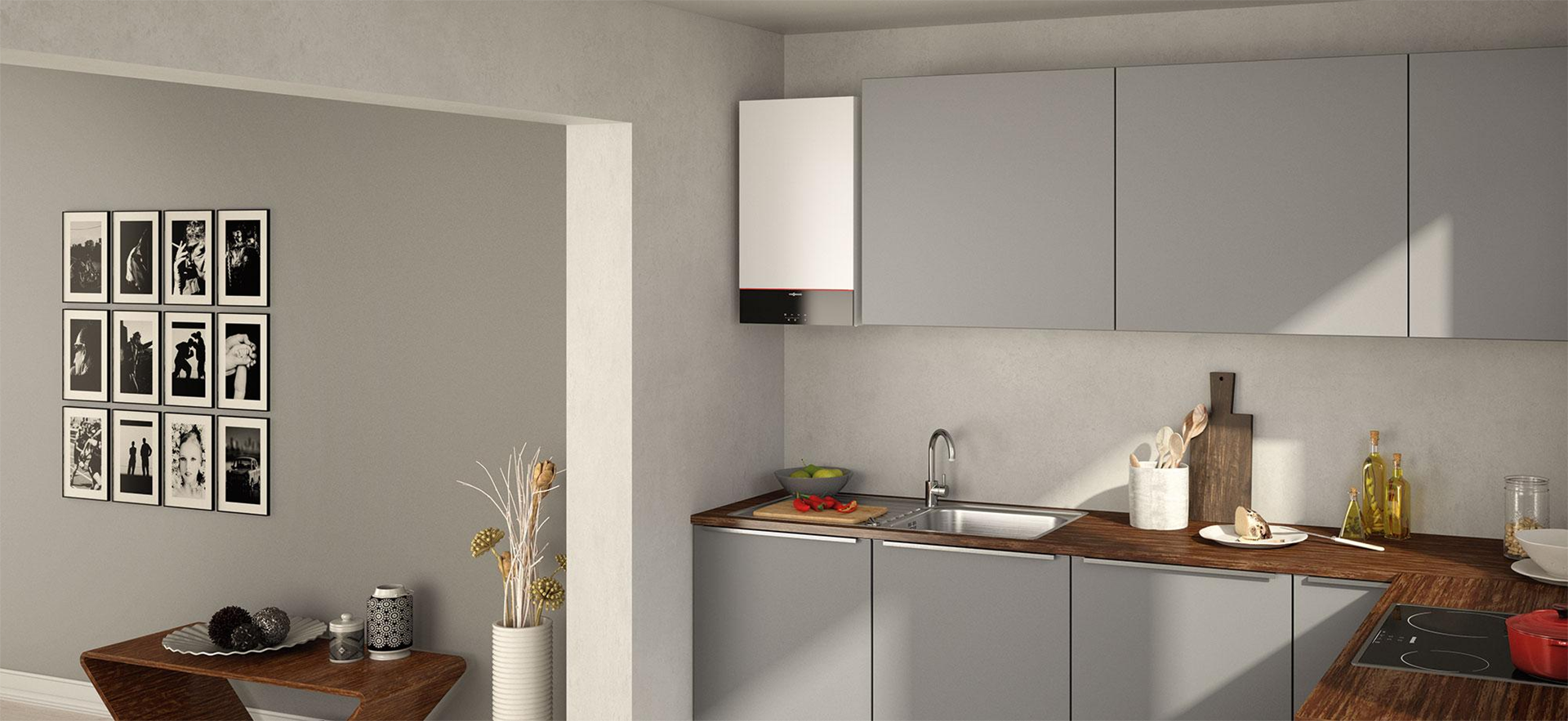 Zdjęcie prezentuje wnętrze kuchni w budynku mieszkalnym. Kocioł gazowy został umieszczony na wysokości szafek znajdujących się nad blatem i całkowicie wkomponował się w wystrój pomieszczenia.