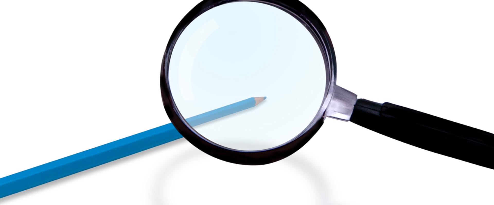Na rysunku znajduje się lupa i widziany przez nią pomniejszony obraz ołówka.
