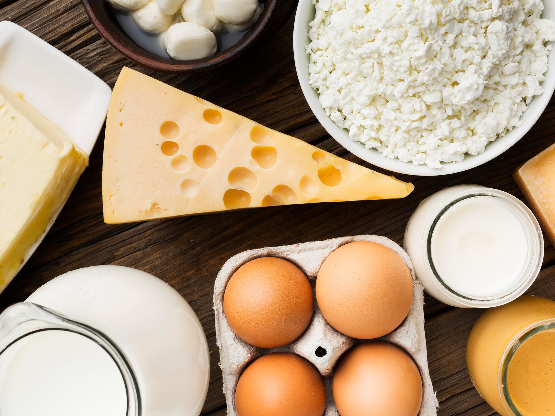 Zdjęcie przedstawia ułożony na blacie nabiał. Widoczne są: ser, jajka, mąka, mleko i twaróg.