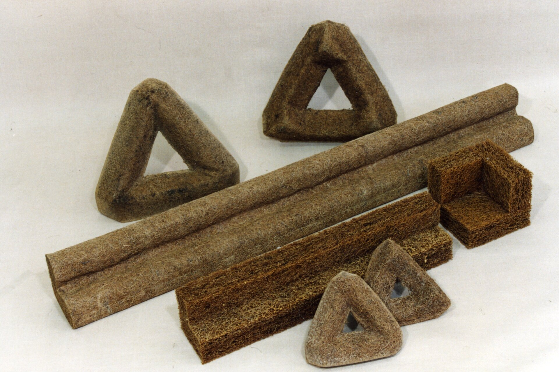 Na zdjęciu widocznych jest kilka brył wykonanych z włókna kokosowego, mają różne kształty. Dwie są podłużne, cztery formują trójkąty, jedna przypomina sześcian, ale złożony z trzech ścian.